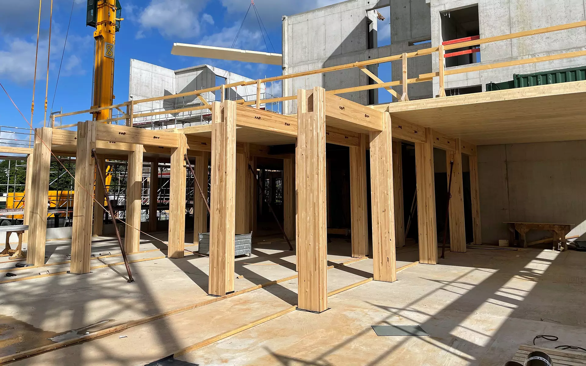 Sicherheitsgeprüfte Baustelle mit Holzstützen und Betonteilen.